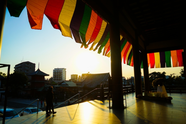 お寺の本堂の周りに張られた五色幕を、内側から見た写真。夕日が五色幕に透けて、五彩の光を感じる。