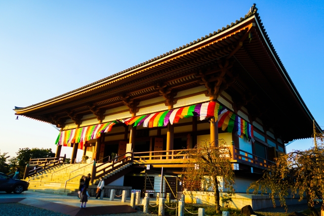 お寺の本堂の周りに張られた五色幕が風にはためいたいる